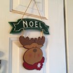 Comic reindeer head below "Noel" banner